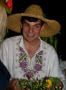 Guy in traditional Slavic clothes holds a wreath in his hands - night action of Ivan Kupala holiday