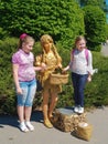 Gold spray painted girl posing with two girls in Kyiv National Botanical Garden