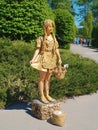 Gold spray painted girl standing on a rock and welcoming visitors in Kyiv National Botanical Garden