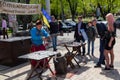 Kiev, Ukraine - April 22, 2018: Man in a Cossack costume makes souvenir coins