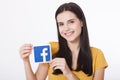 KIEV, UKRAINE - August 22, 2016: Woman hands holding facebook icon sign printed on paper on white background. Facebook