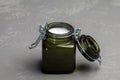 KIEV, UKRAINE - DECEMBER 11, 2020: Small scented candle in a green glass candlestick with a tight lid.