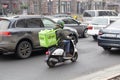 Kiev, Ukraine - February 20, 2019: Food delivery man drive scooter with green Uber eats backpack behind back