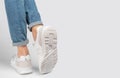 Kiev, Ukraine - January 03, 2021: White women`s casual sneakers from New Balance brand on a light background. Young girl in jeans Royalty Free Stock Photo