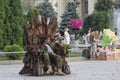 Kiev, Ukraine - July 28, 2019: Man in military uniform sits on a chair made from shrapnel of munitions collected