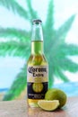 Kiev -Ukraine , 25 June 2018-Corona extra a bottle of cold beer and a fruit of lime on the background of palm trees in nature in