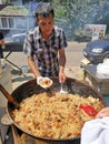 Kiev, Ukraine, 06.07.2018. A man prepares pilaf on the street in a cauldron