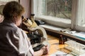 KIEV, UKRAINE, MARCN, 2017: The laboratory assistant conducts medical examination with the help of microscope, Kiev, Ukraine