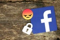 Facebook icon with lock and angry emoji smile
