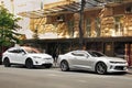 Kiev, Ukraine - May 22, 2021: White electric car Tesla Model X and Gray american muscle car Chevrolet Camaro parked in the city