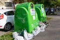 Green overfilled bins for collecting and recycling plastic and glass
