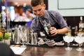 KIEV, UKRAINE - 30 OCTOBER, 2016: Barman festival. Young handsome bartender is making cocktail.