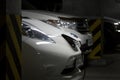 Kiev, Ukraine - October 10, 2017: Nissan Leaf electric car charging at underground parking. Fuel gasoline car on background. Conn