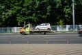 Kiev, Ukraine - 07.26.2019: Recovery truck to transport automobile on highway in the city. Vehicle carrier transporting white car
