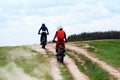 Kiev, Ukraine, 17.05.2020: Two motorcyclists travel forward to the mountain on a dirt road, at sports races. Greens, nature and