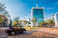 Kigali, Rwanda - September 21, 2018: A car passes the city centre roudabout, with Pension Plaza and surrounding buildings in Royalty Free Stock Photo
