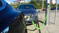 Tesla electric car and hybrid volvo charging batteries at plug in charge station in the Netherlands