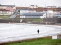 Kilkee, Ireland - 01.14.2023: People walking on the beach. Town building in the background. Calm Atlantic ocean. Popular travel