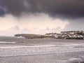 Kilkee, Ireland - 01.14.2023: People walking on the beach. Town building in the background. Calm Atlantic ocean. Popular travel