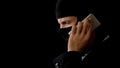 Killer in balaclava talking on phone, planning crime with partners, corruption