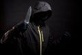 Killer in black holds the knife in aggressive style. Selective focus Royalty Free Stock Photo
