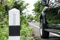 A kilometer stone on the Country road with the car background.