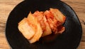 Kimchi Closeup, Kimchee Texture on Black Plate, Red Spicy Kim Chi, Hot Fermented Napa Cabbage