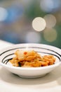 Kimchi, that is a korean side dish, is in small white bowl with blurred lights bokeh background. Royalty Free Stock Photo