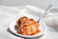 Kimchi is placed in a white plate with a fork on its side Royalty Free Stock Photo