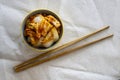 Kimchi in plate with chopsticks on light fabric