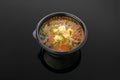 Kimchi soup with tofu cheese, seaweed, kimchi sauce, handashi, green onion, egg, sesame In a container for delivery. View from Royalty Free Stock Photo