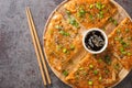Kimchijeon is a Korean savory crispy pancake made of kimchi with flour and onion closeup on the wooden board. Horizontal top view