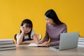 A kind Asian female private tutor is teaching math to a cute little girl at a study table Royalty Free Stock Photo