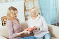 Kind attentive grandmother giving a lovely present to her grandchild