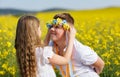 Sister puts on brother Ukrainian wreath with ribbons, against background of fields and sky