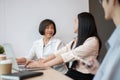 A kind and friendly senior female boss is sharing her opinions and working with young colleagues Royalty Free Stock Photo