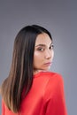 Gorgeous young woman walking in her red dress and looking calm