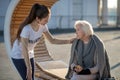 Kind-hearted young volunteer coming to poor homeless woman Royalty Free Stock Photo