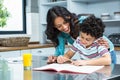 Kind mother helping her son doing homework Royalty Free Stock Photo