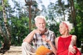 Kind pensioner offering fruit to her husband during their picnic Royalty Free Stock Photo