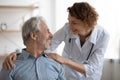 Kind smiling female doctor embracing encouraging happy senior male patient Royalty Free Stock Photo
