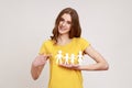 Kind smiling positive teenager girl in yellow t-shirt pointing at paper chain people which holding in hands, happy family, Royalty Free Stock Photo