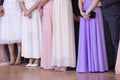 Kind of women`s legs in stylish shoes and beautiful ball gowns on the background Royalty Free Stock Photo