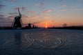 Kinderdijk - Geese flying over sunrise on the frozen windmills alignment