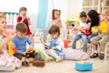 Kindergarten teacher with children on music lesson in daycare. Little kids toddlers play together with musical toys. Royalty Free Stock Photo