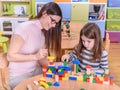 Kindergarten Teacher Playing with Child with Toy Blocks Royalty Free Stock Photo