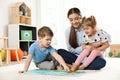Kindergarten teacher reading book to children. Learning and playing Royalty Free Stock Photo