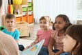 Kindergarten teacher reading book to cute little children Royalty Free Stock Photo