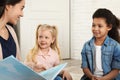 Kindergarten teacher reading book to cute little children Royalty Free Stock Photo