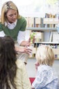 Kindergarten teacher showing seedling to children